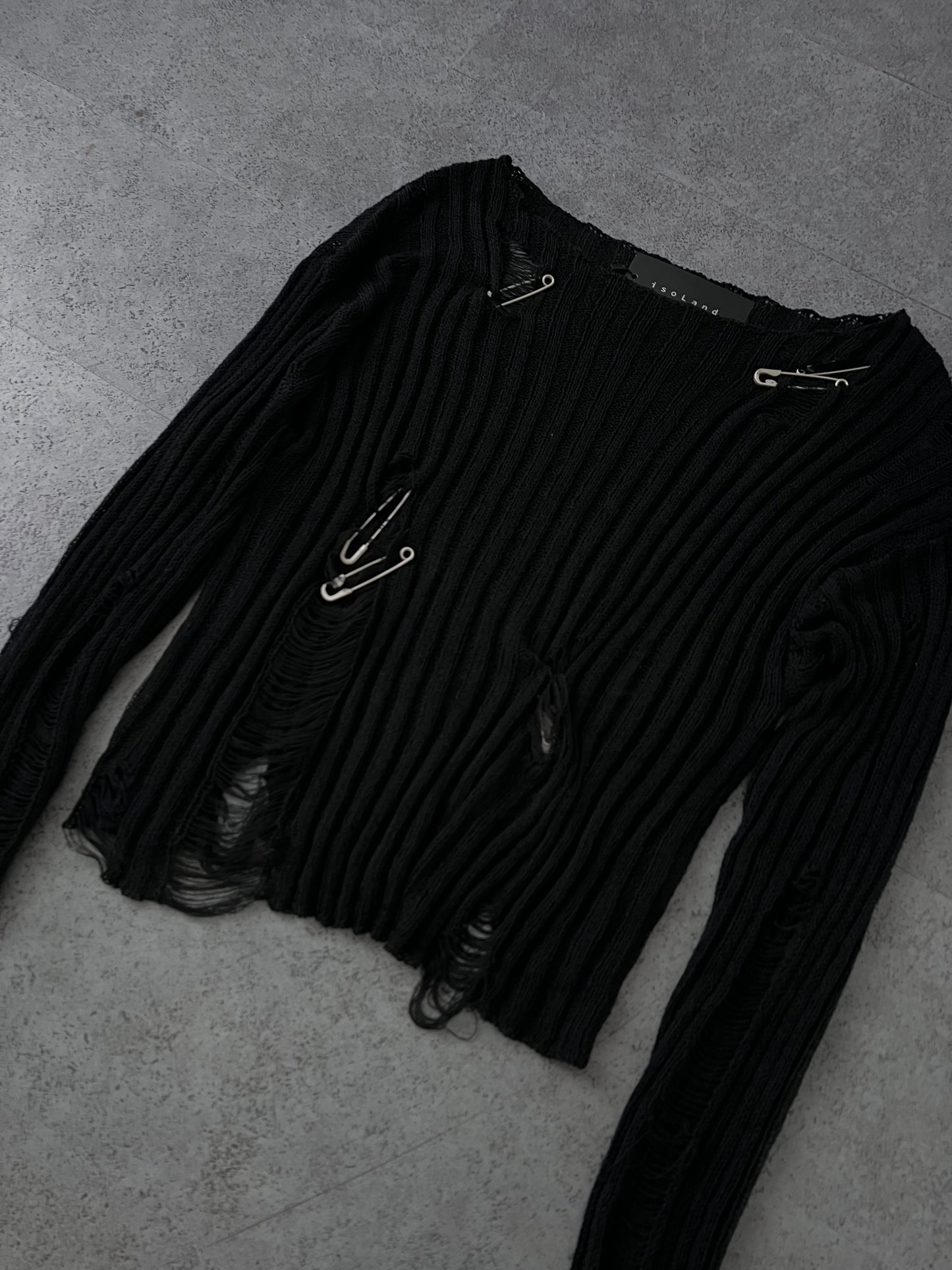 Damaged knitwear with pin
